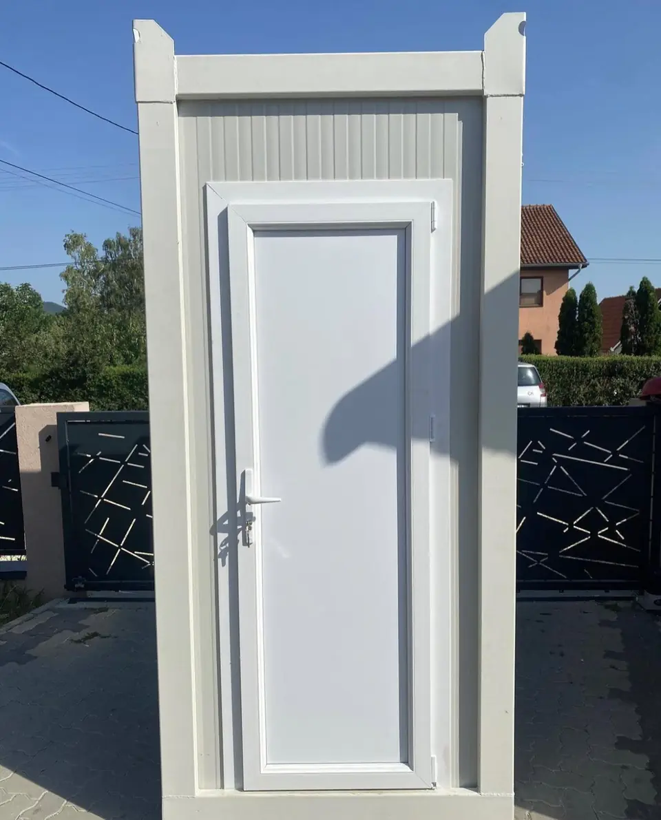 White flushing restroom unit with paneled door, the kind of unit delivered in Cushing