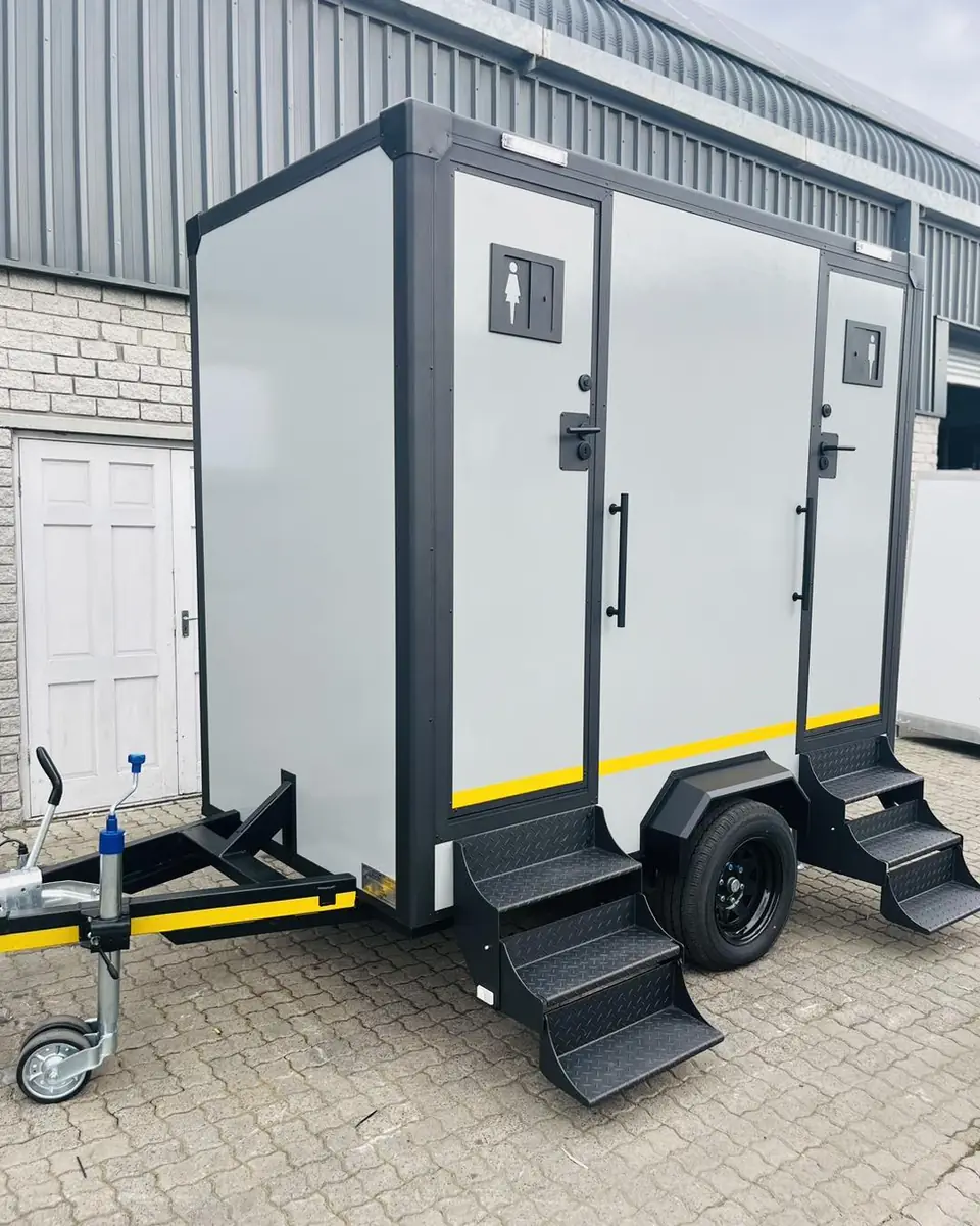 Two-room restroom trailer with fold-down steps, the kind of unit delivered in Skiatook